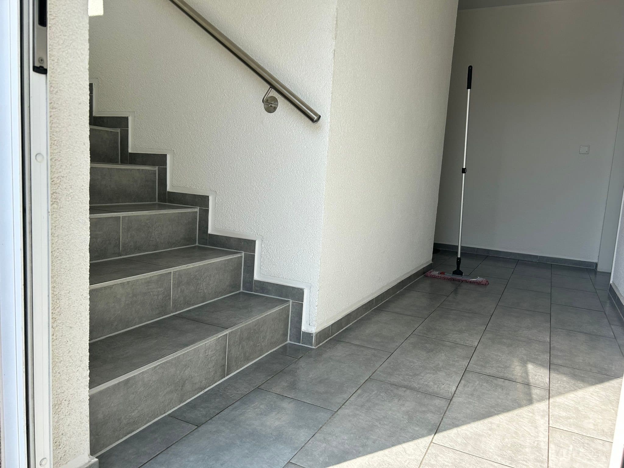 Professionelle Reinigungskraft beim Saugen eines Treppenhauses in Essen